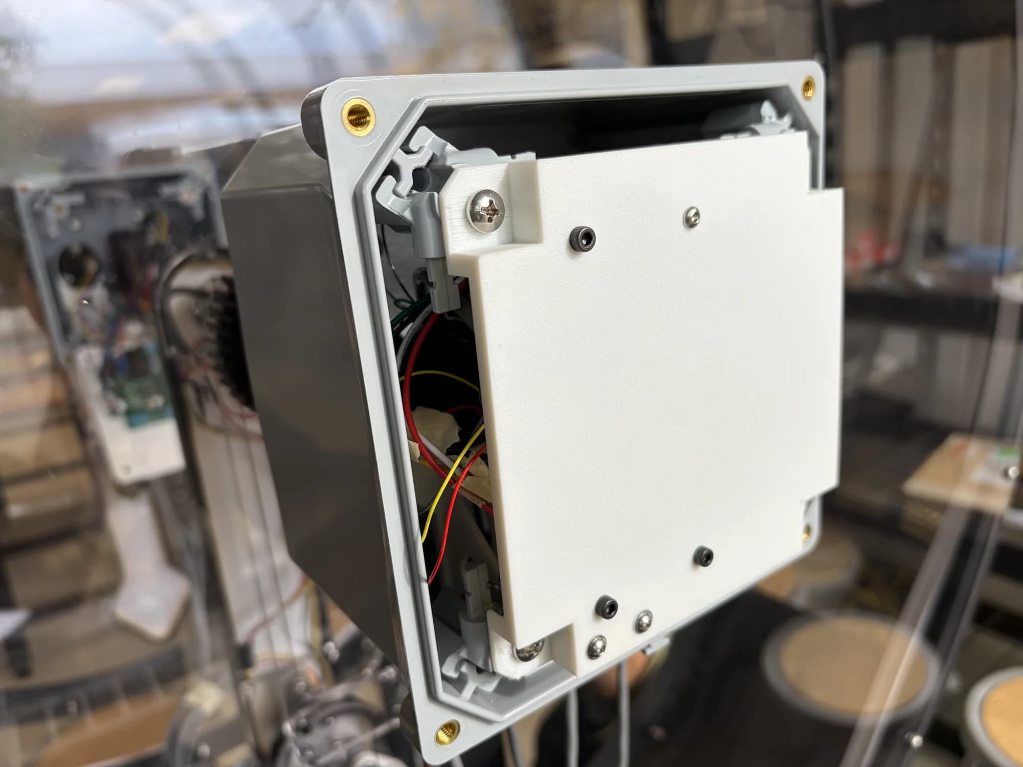 Physical motor enclosure with its fitted internal mounting plate and wiring